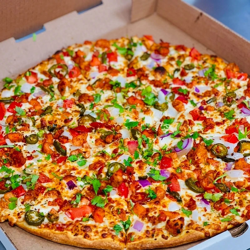 Spicy butter chicken pizza made with homemade butter chicken sauce at Lava Pizza YYC Beltline